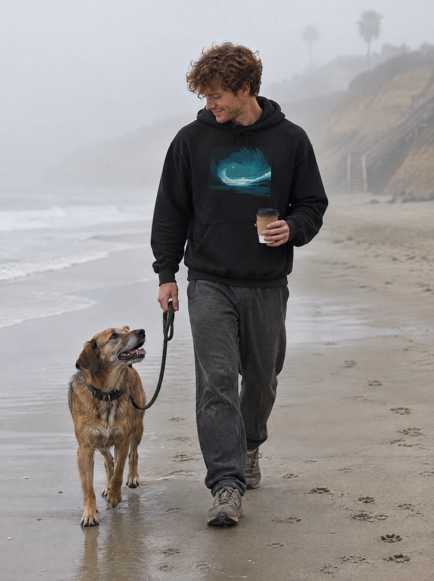 Pacific Hoodie on a foggy beach walk with a dog and coffee